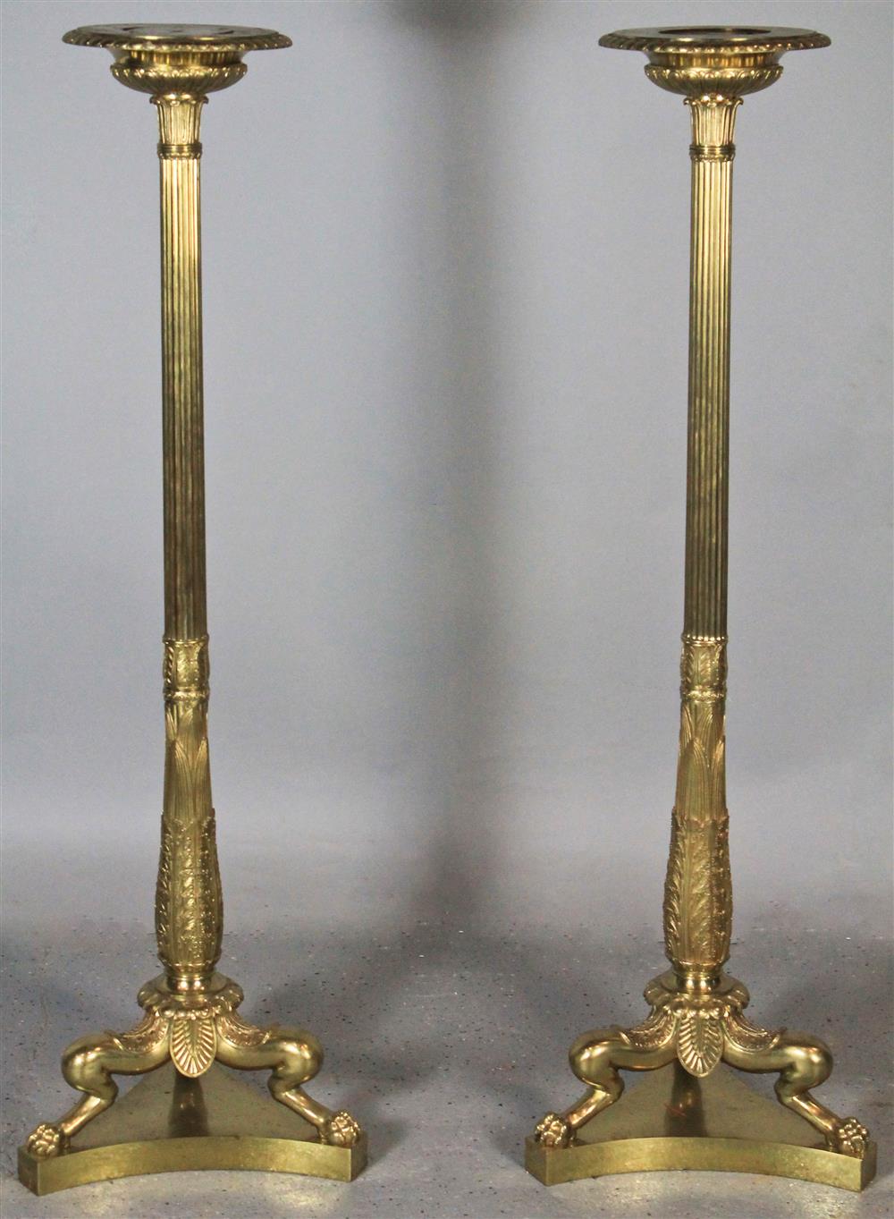 Appraisal: PAIR OF EMPIRE BRASS TORCHERES each circular top on reeded