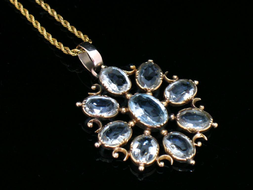 Appraisal: AN EDWARDIAN AQUAMARINE CLUSTER PENDANT set in an open scrolling