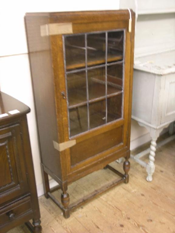 Appraisal: A medium oak bookcase single leaded glazed door enclosing two