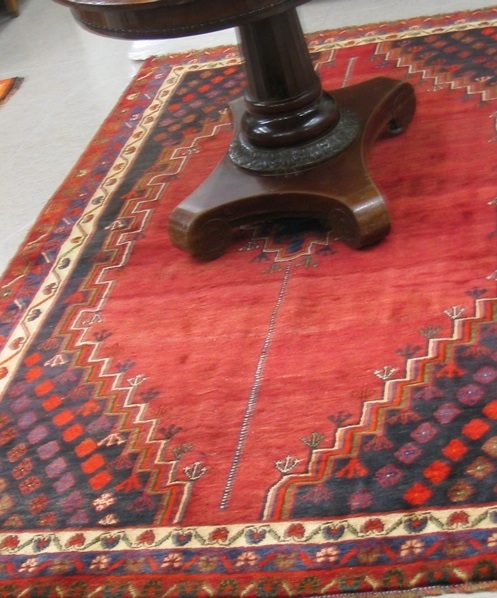 Appraisal: PERSIAN SHIRAZ AREA RUG having a plain diamond-shaped brownish-red field