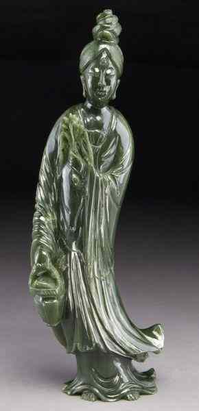 Appraisal: Chinese carved spinach jade Guanyinone hand holding a basket the