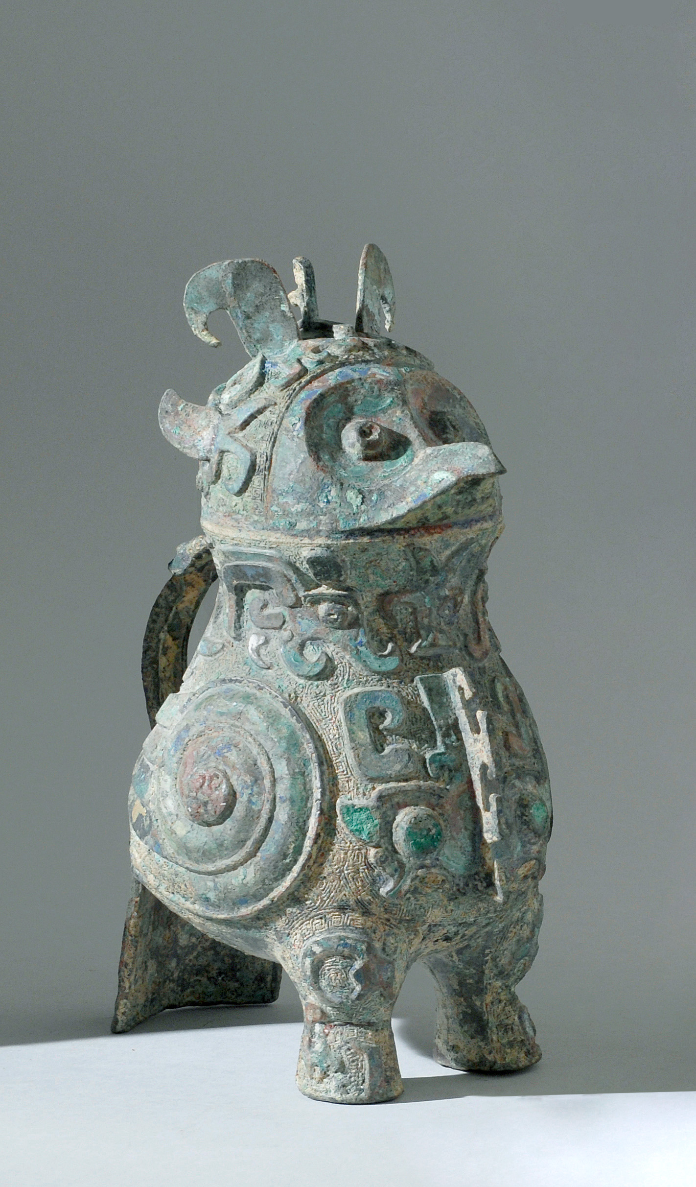 Appraisal: BRONZE BIRD-FORM VESSEL Archaic StyleWith relief mask designs Base formed