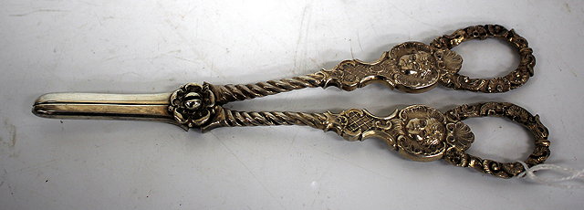 Appraisal: A PAIR OF VICTORIAN SILVER GRAPE SCISSORS with cherub mask