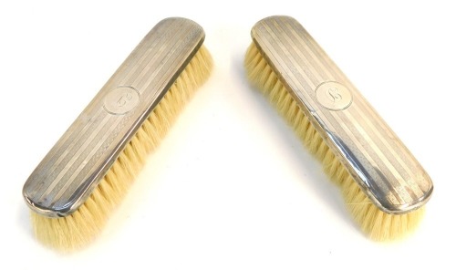 Appraisal: Two George V silver backed dressing table brushes each with