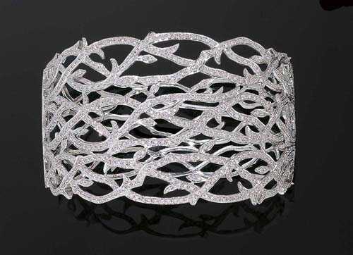 Appraisal: BRILLIANT-CUT DIAMOND BANGLE White gold Elegant broad bangle with branch