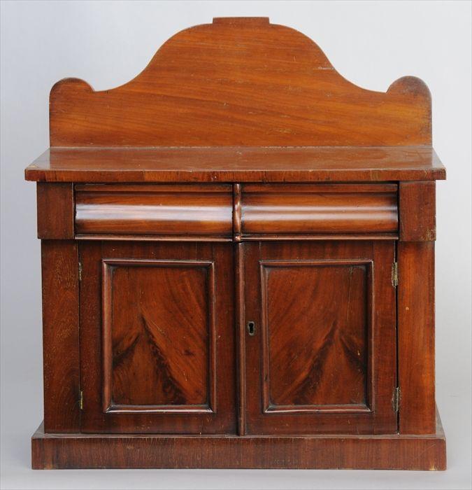 Appraisal: LATE CLASSICAL MAHOGANY MINIATURE SIDEBOARD The shaped backsplash over rectangular