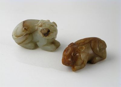 Appraisal: A striated jade carving of a crouching lion dog and