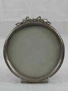 Appraisal: A circular silver frame with ribbon cresting and strut back