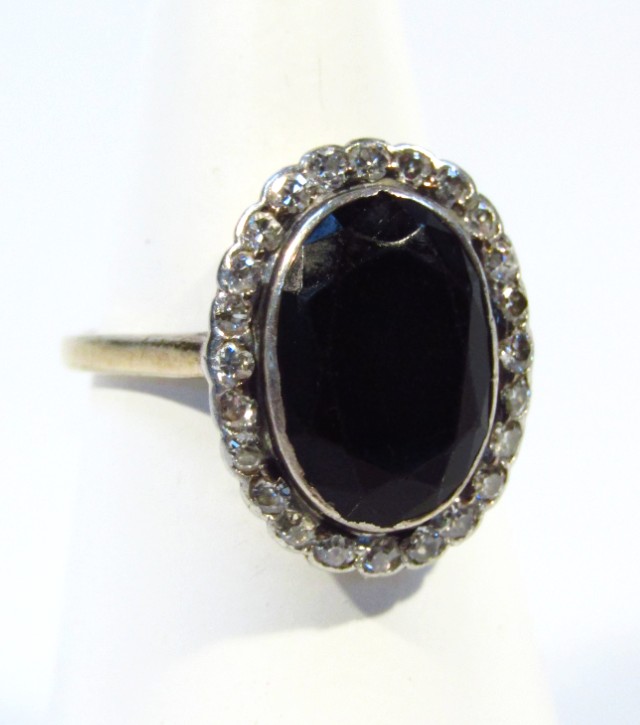 Appraisal: A ladies dress ring centred by a cut dark stone