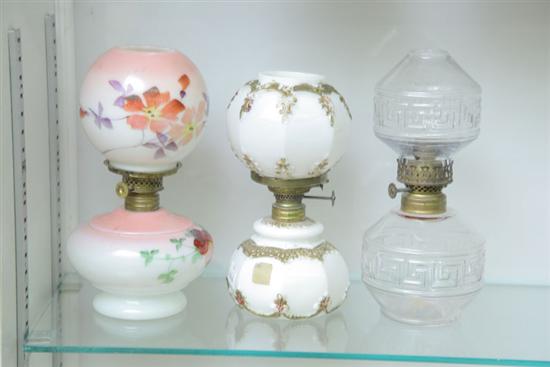 Appraisal: THREE MINIATURE GLASS LAMPS WITH SHADES One hand painted milk