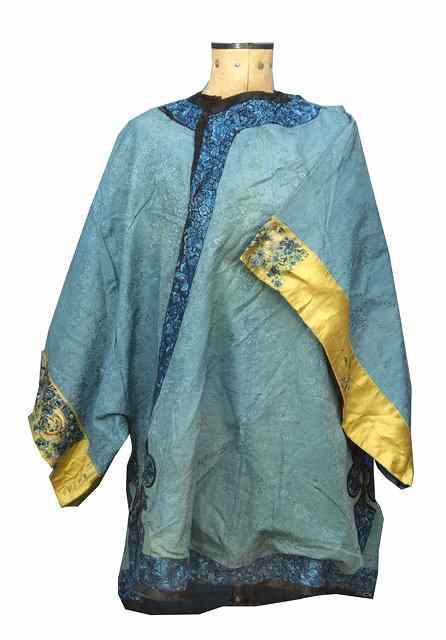 Appraisal: A CHINESE BLUE SILK TUNIC with finely sewn border on