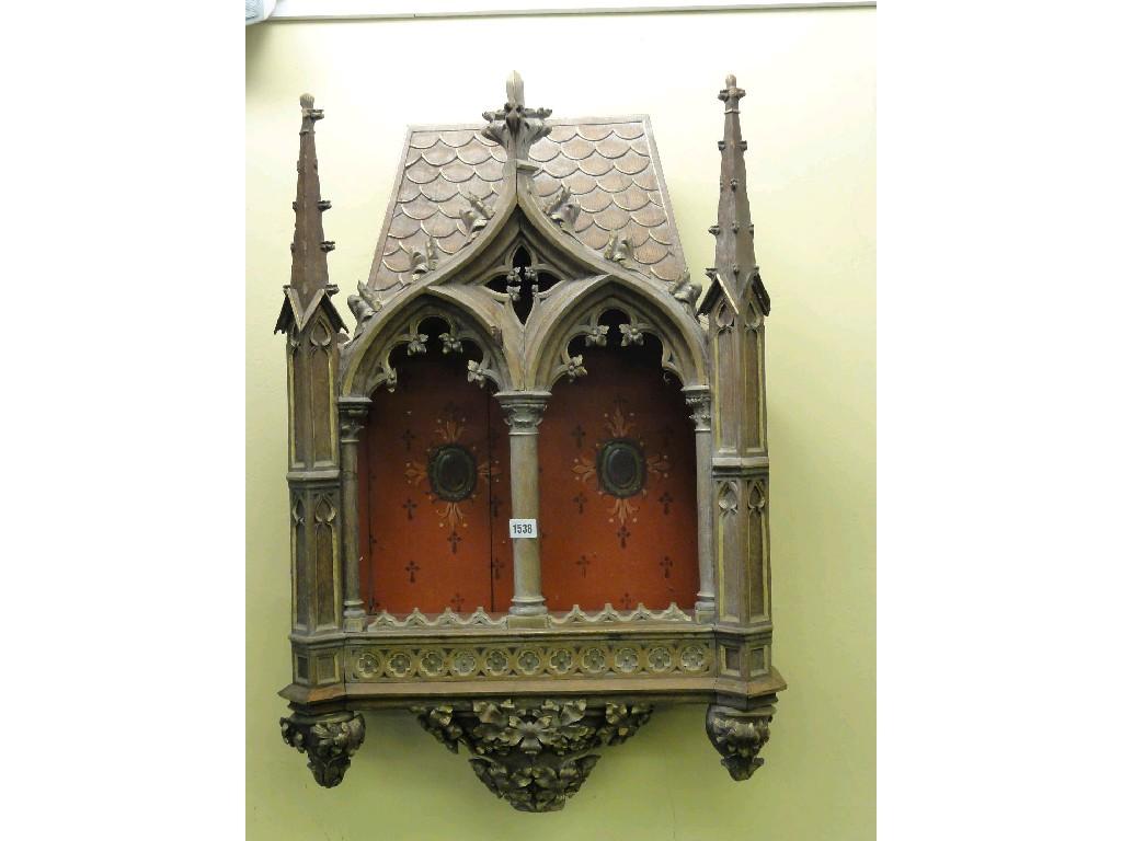 Appraisal: An ecclesiastical oak wall cabinet with gothic tracery carved mouldings