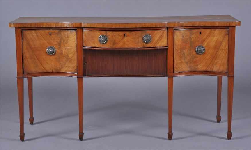 Appraisal: GEORGE III MAHOGANY SERPENTINE-FRONT SIDEBOARD The central frieze drawer with