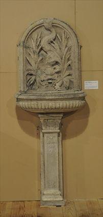 Appraisal: LIMESTONE WALL FOUNTAIN The cresting with dolphin decoration and oval