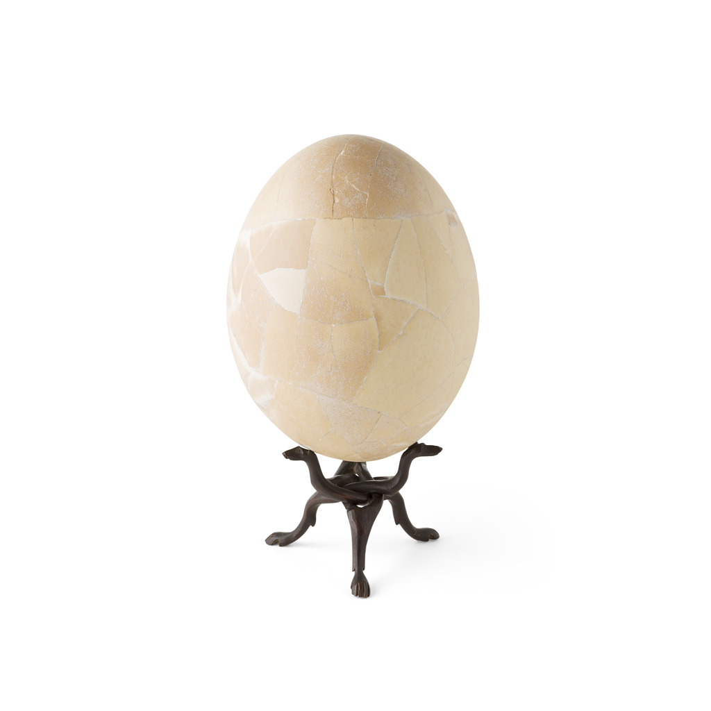 Appraisal: REASSEMBLED AEPYORNIS ELEPHANT BIRD EGG raised on a fold-away carved