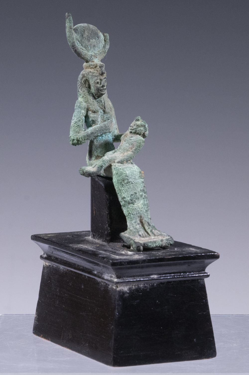 Appraisal: MINIATURE EGYPTIAN BRONZE SCULPTURE Statuette of Isis nursing Horus on