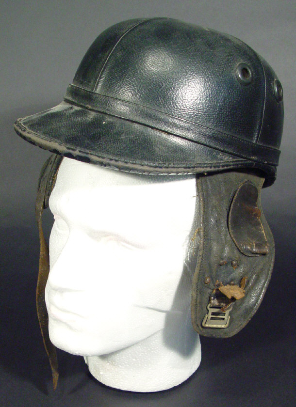 Appraisal: Black leather military helmet with earflaps indistinctly marked to the