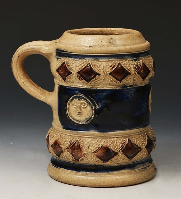 Appraisal: A RHENISH STONEWARE TANKARD with three face mask roundels on