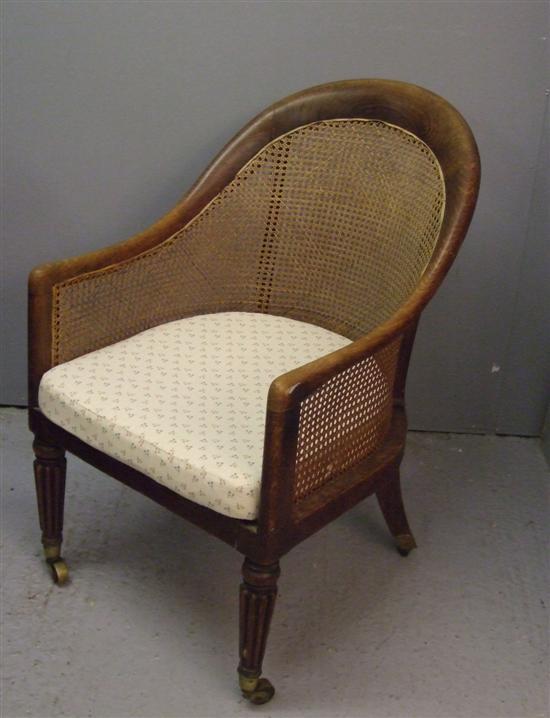 Appraisal: th century mahogany framed bergere tub chair on reeded tapering