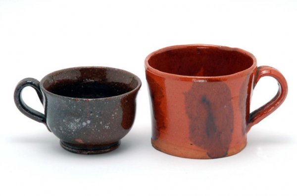 Appraisal: Two redware mugs The first is a straight-sided flared redware