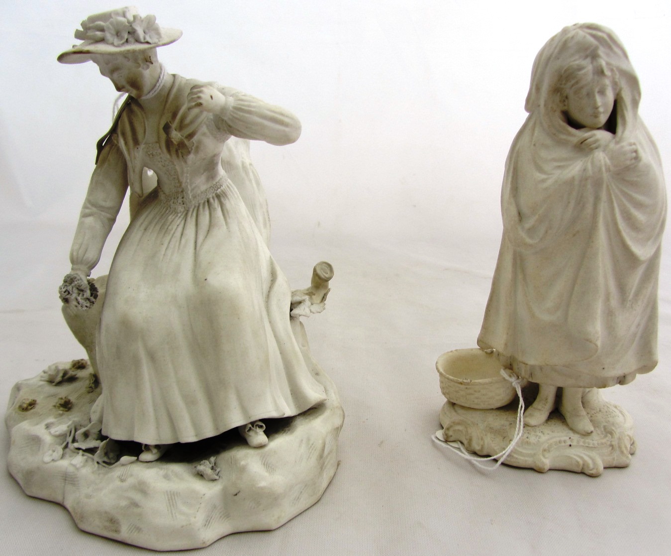 Appraisal: A Derby white biscuit model of a shepherdess seated on