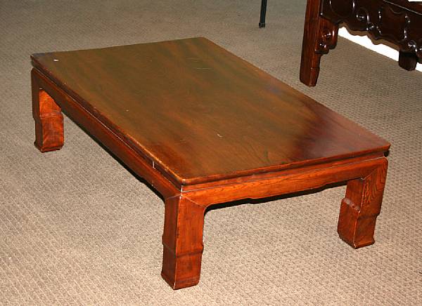 Appraisal: A keyaki wood coffee table Its thick legs carved in