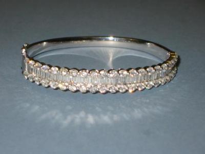 Appraisal: A DIAMOND BANGLE set with a row of baguette diamonds