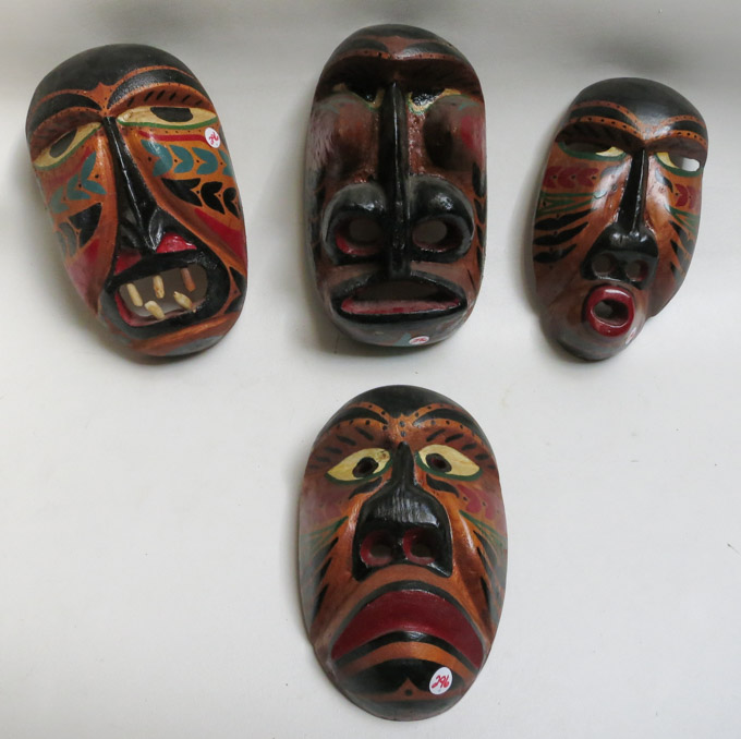 Appraisal: FOUR ALASKAN CARVED AND PAINTED WOOD MASKS with stylized angular