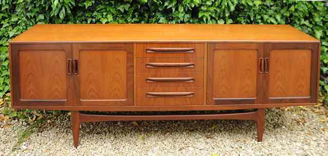 Appraisal: A TH CENTURY TEAK SIDEBOARD with four cupboard doors and