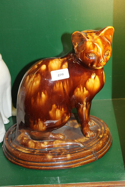 Appraisal: A VICTORIAN TREACLE GLAZE POTTERY MODEL OF A CAT on