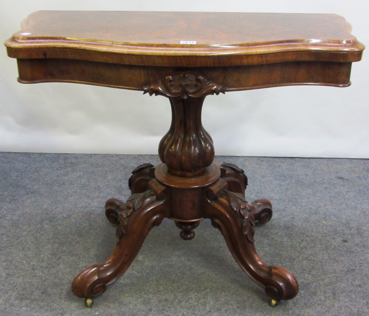 Appraisal: A Victorian figured walnut card table with serpentine top on