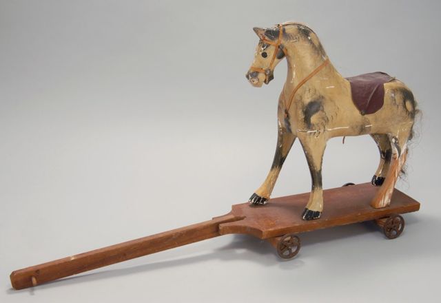 Appraisal: PAINTED WOODEN HORSE-FORM PULL-TOY On wooden platform with cast metal