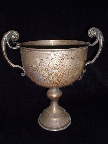 Appraisal: A trophy cup with scroll handles on a knopped support