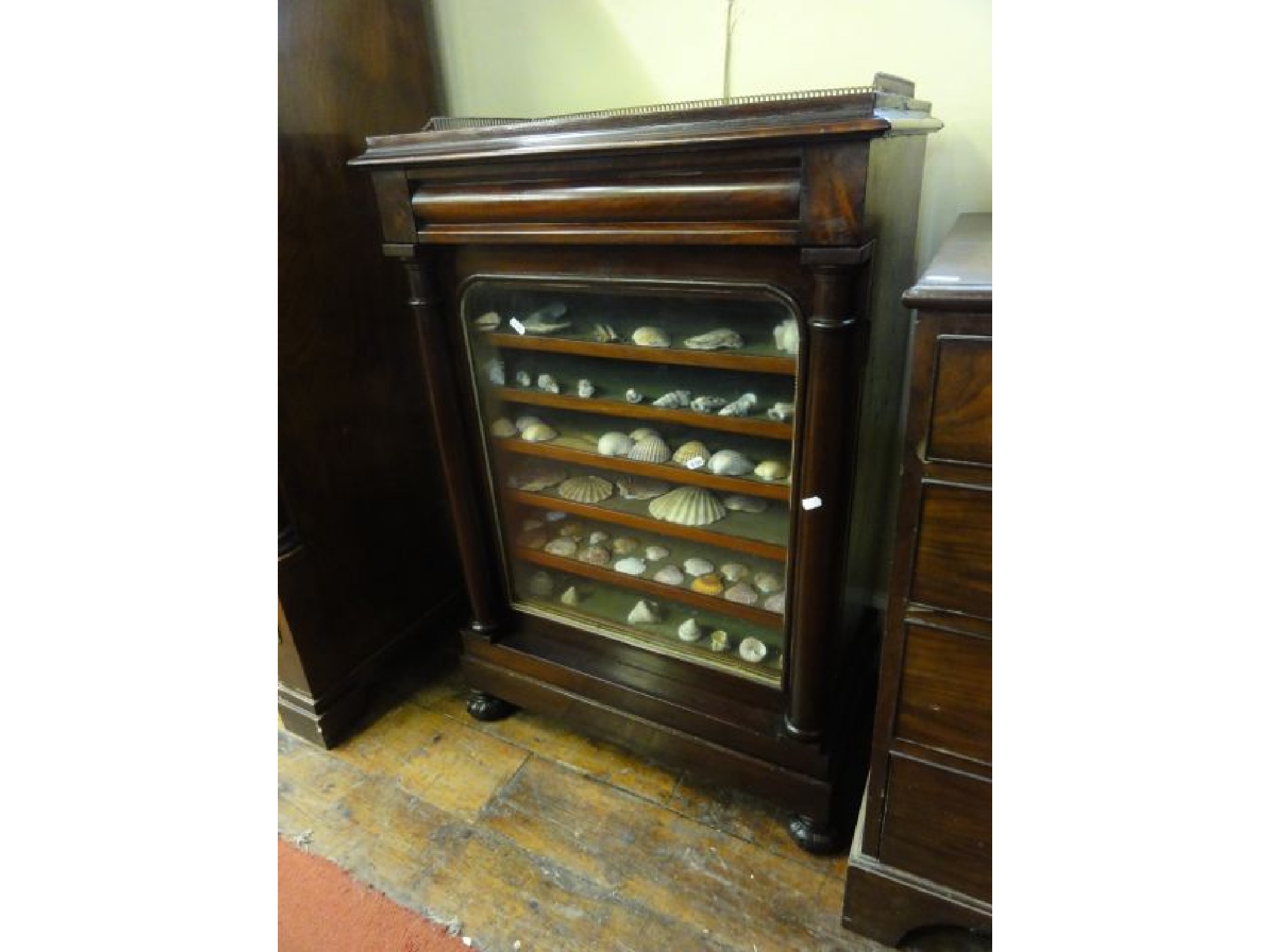 Appraisal: A Victorian mahogany side cabinet with glazed door and column