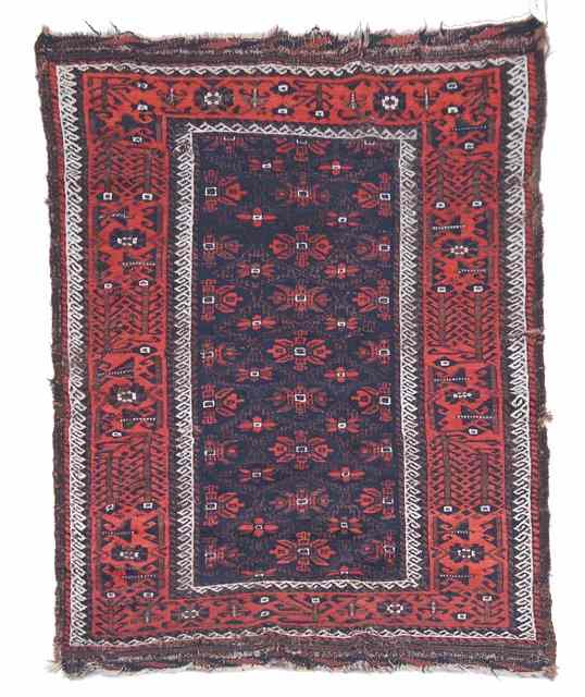 Appraisal: AN OLD BELOUCH RUG with stylised foliate central panel and