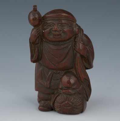 Appraisal: A Carved Wood Netsuke of a Traveler Well carved man