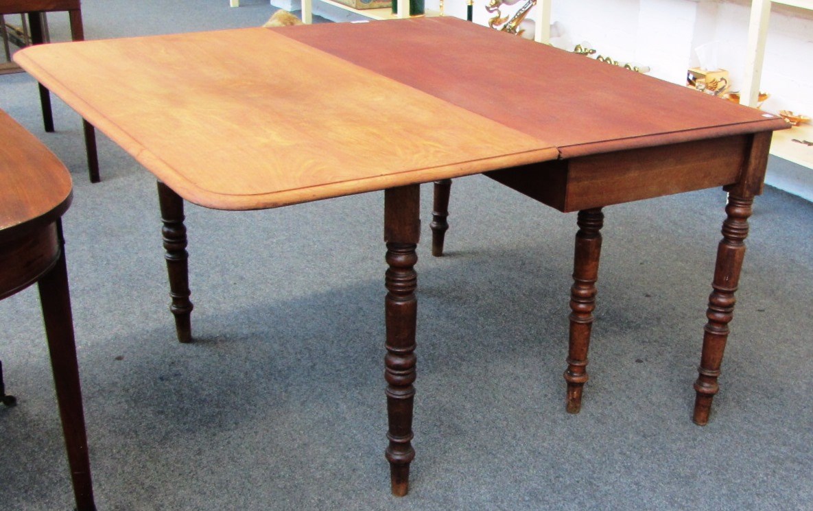 Appraisal: A George III mahogany drop flap dining table on turned