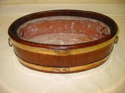 Appraisal: A MAHOGANY COOPERED JARDINIERE of oval tapering form with brass