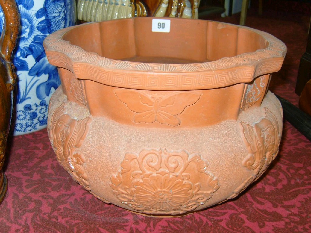 Appraisal: An oriental terracotta jardinihre with relief decoration of butterflies flower