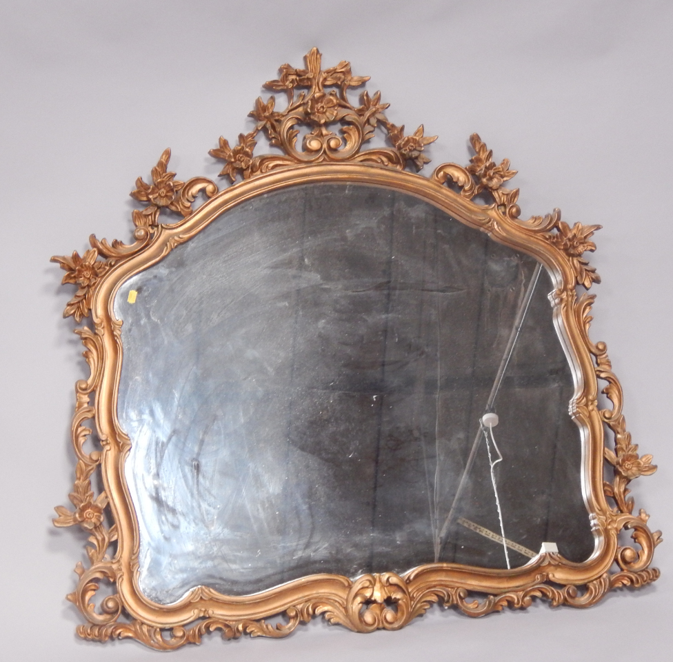 Appraisal: A Victorian rococo style giltwood wall mirror carved with flowers