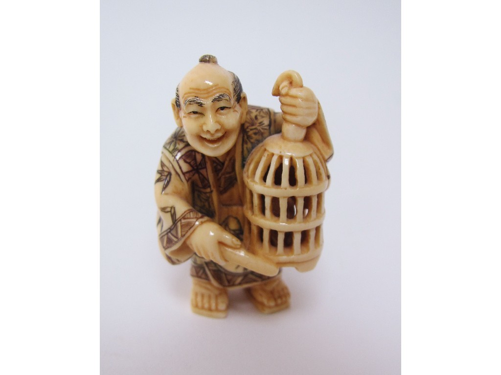 Appraisal: A Japanese ivory netsuke of a man holding a bird