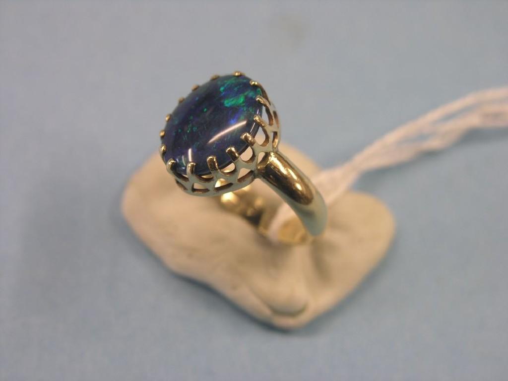 Appraisal: A ct gold doublet ring claw setting enclosing black opal-effect