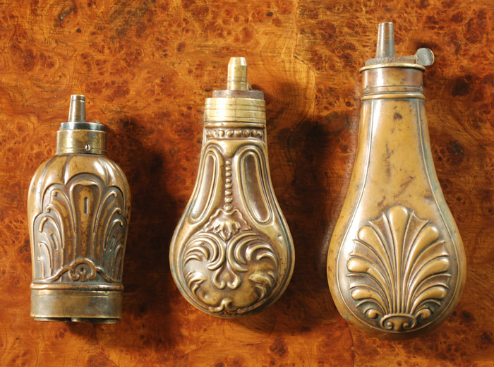 Appraisal: THREE SMALL COPPER AND BRASS POWDER FLASKS gentleman's bottle shape