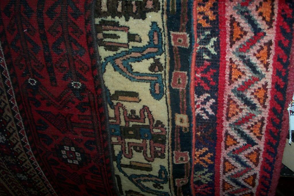 Appraisal: An eastern red ground wool rug with repeating hooked and