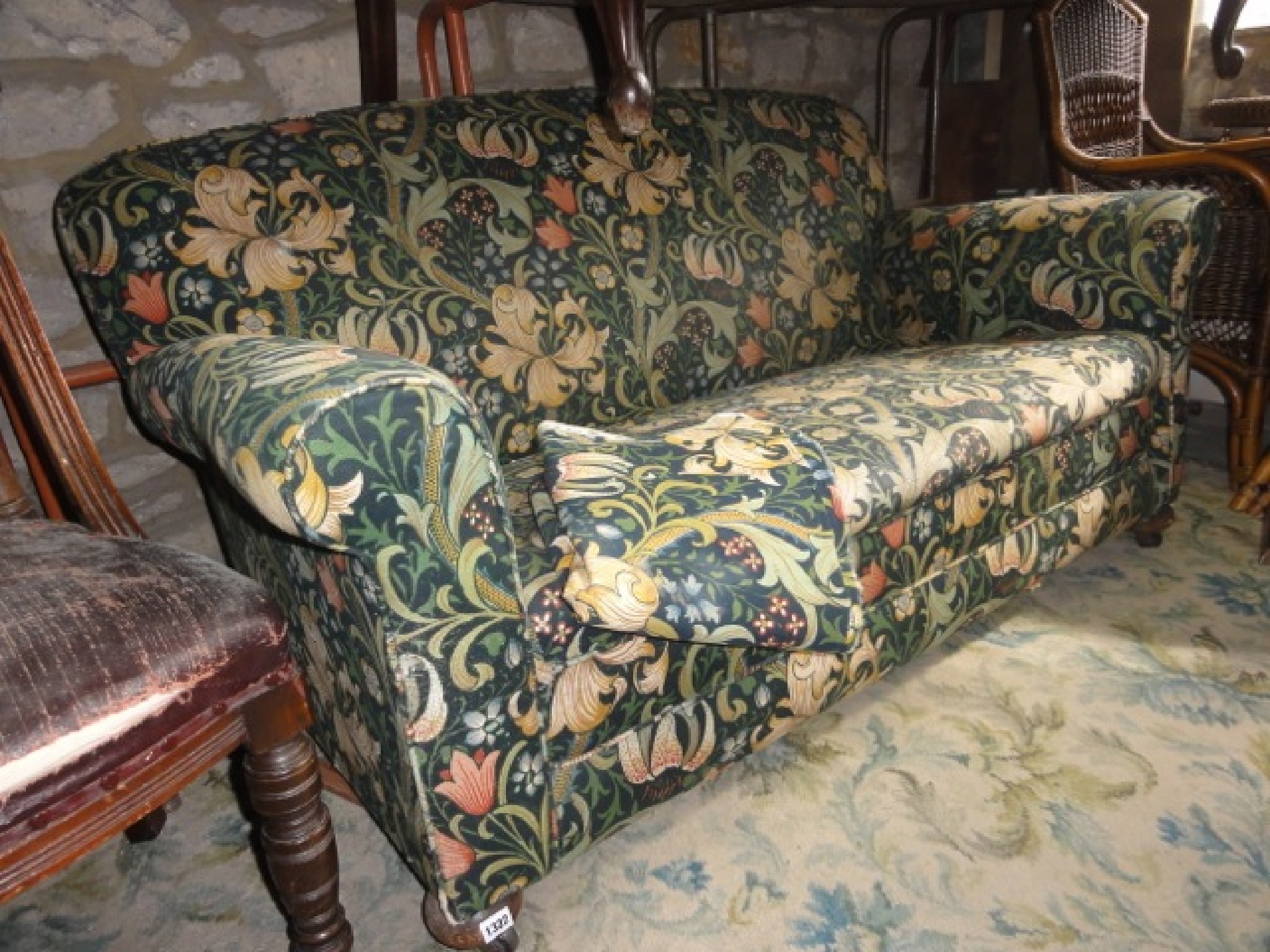 Appraisal: An Edwardian two seat sofa with rolled arms upholstered in