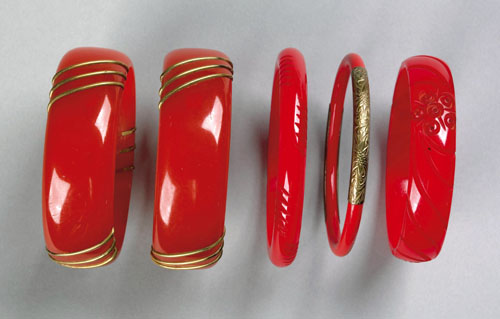 Appraisal: Five red bakelite bangles carved and with brass embellishments