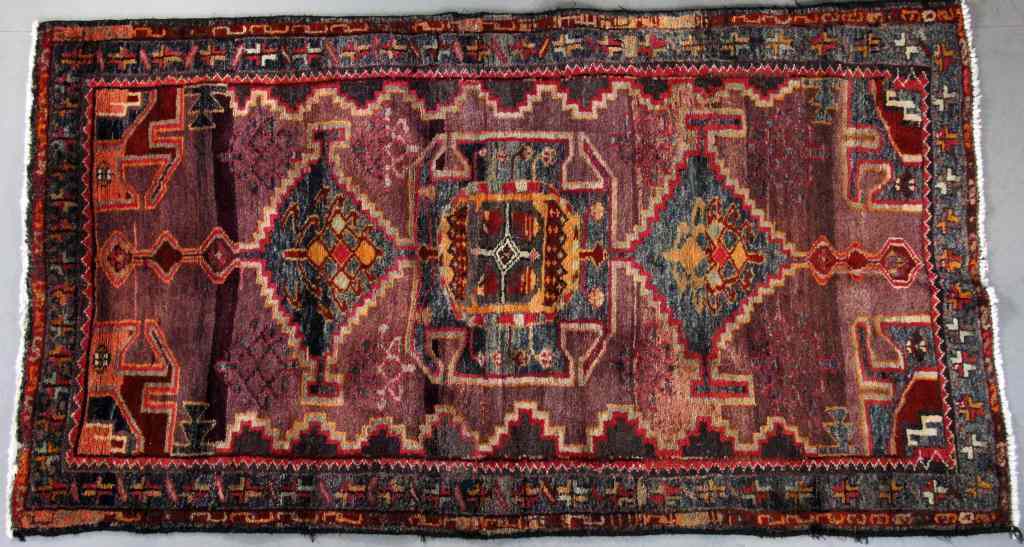 Appraisal: Oriental Wool RugIn reds and blues having multiple cross decoration