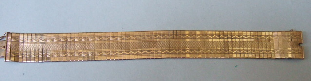 Appraisal: A gold bracelet in a wide bar link design with