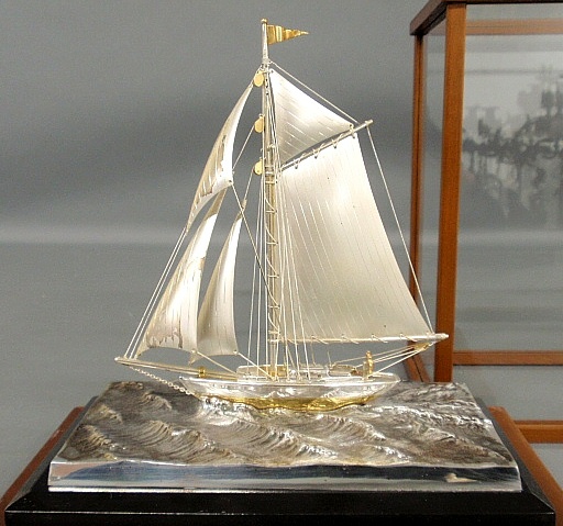 Appraisal: - Glass and mahogany cased sterling silver sailing yacht on