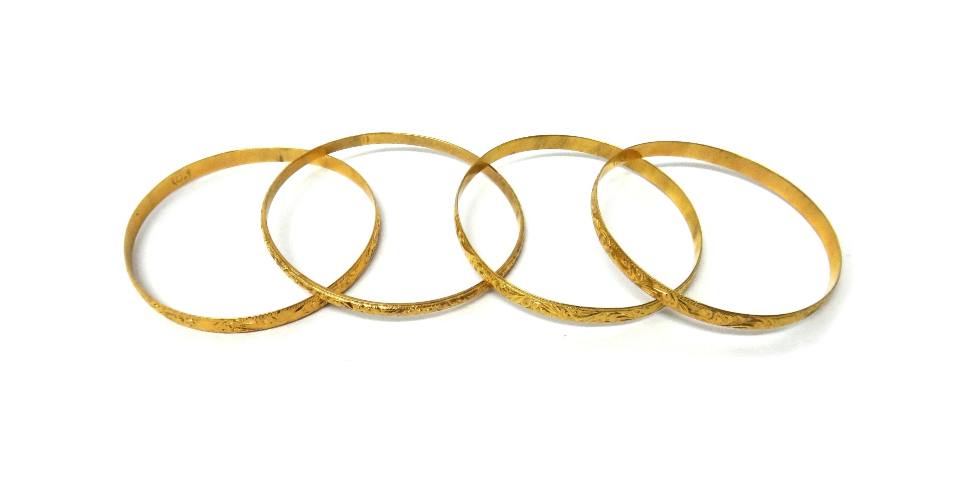 Appraisal: A gold circular bangle with engraved decoration detailed K and